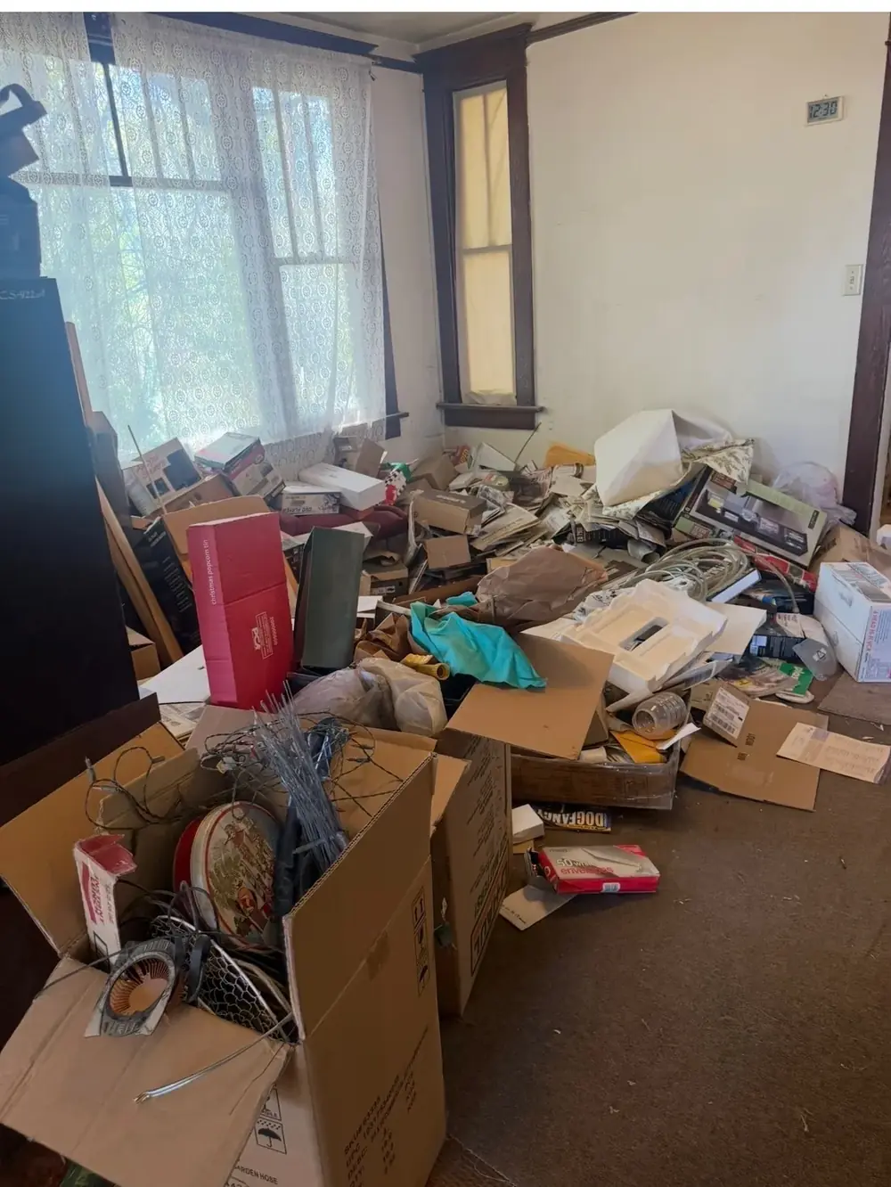 Front room of a Utah rental packed with boxes, papers, and belongings before move-out