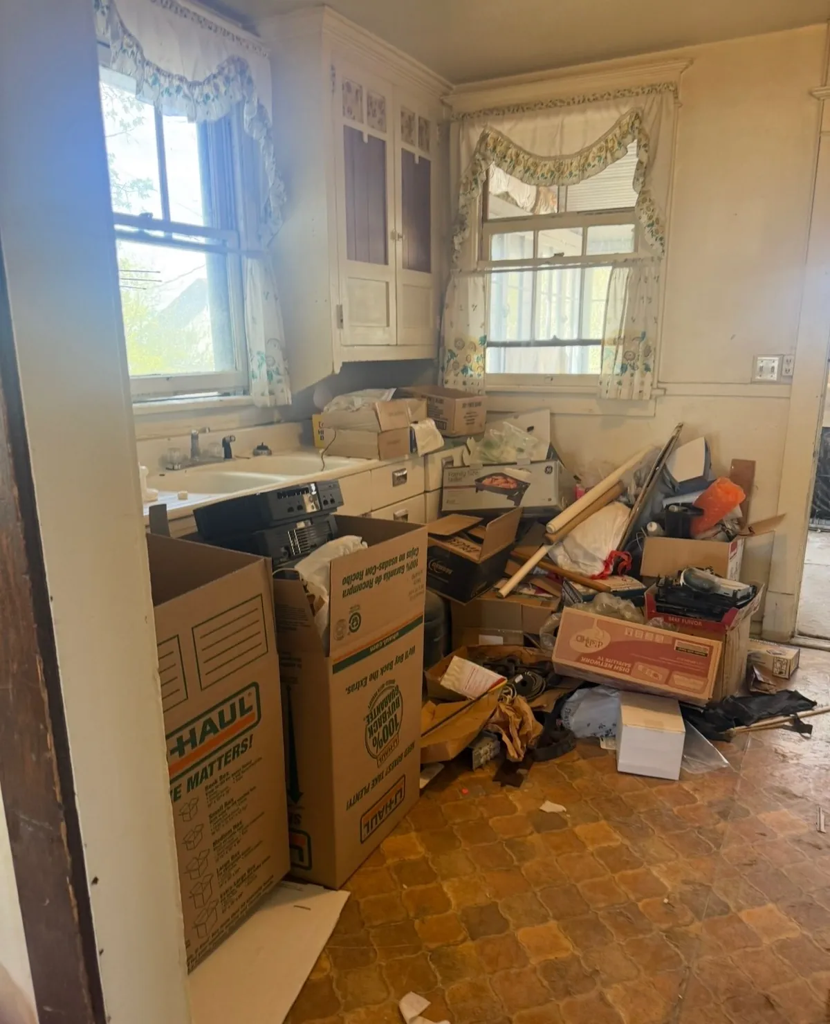 Kitchen mid-pack with moving boxes stacked by the sink