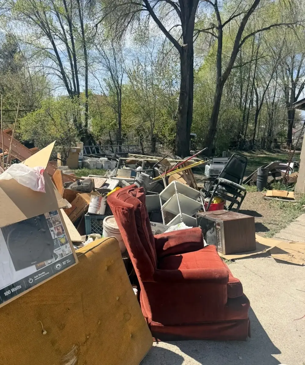 Furniture and household items staged in the yard for dumpsters and trailer loads